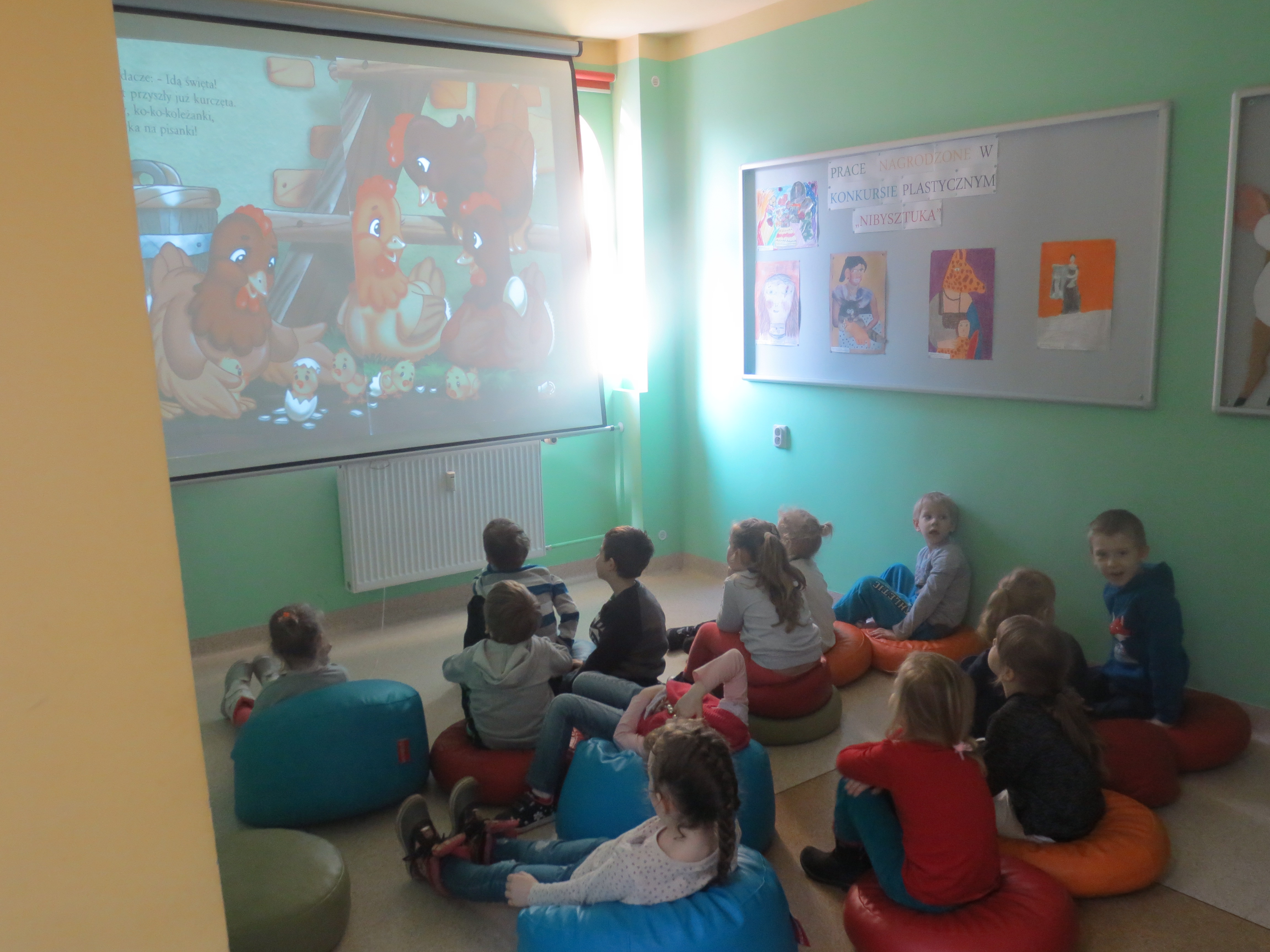 Dzieci oglądają prezentację książki Kozłowska Urszula: O wiośnie, kurczętach i wielkanocnych świętach
