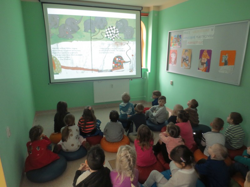 Dzieci oglądają prezentację multimedialną książki McKee D.: Elmer i motylek