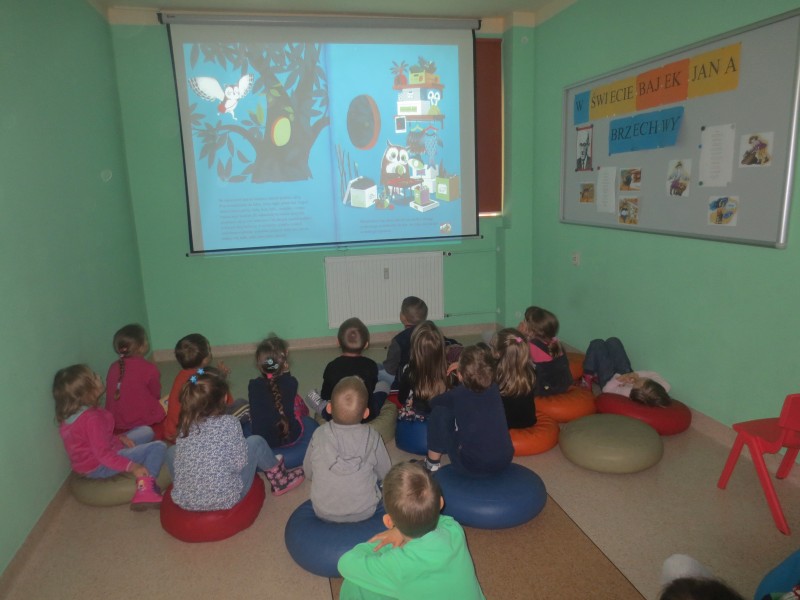 Dzieci słuchają i oglądają książkę